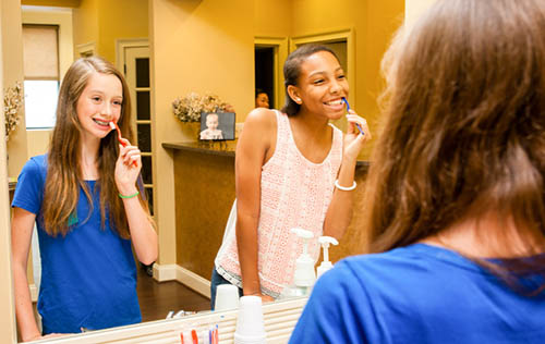 kids taking care of braces in front of mirror Alpharetta Georgia