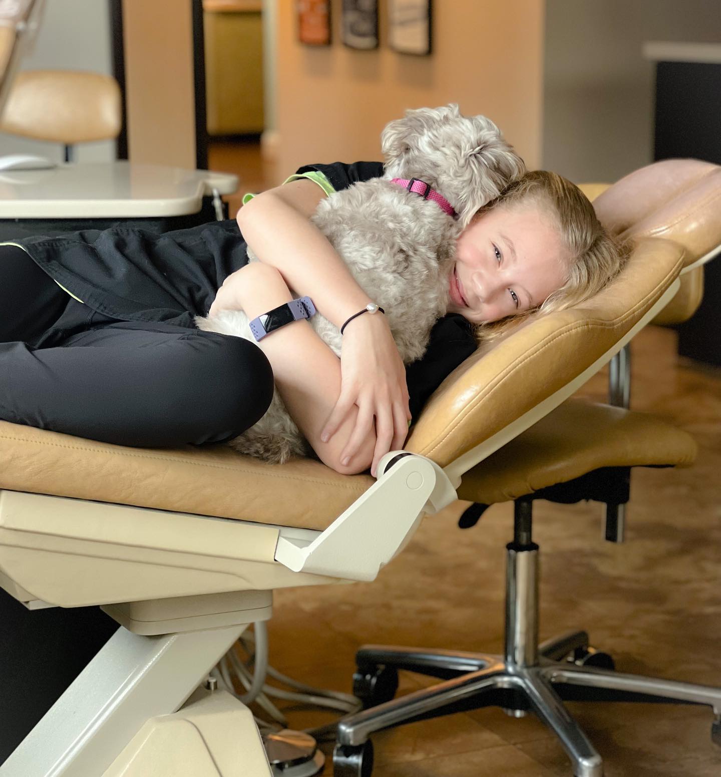 young boy hugging dog at orthodontist